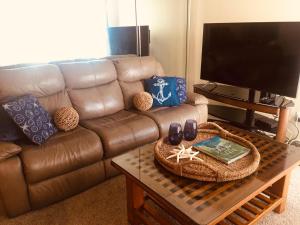 - un salon avec un canapé en cuir brun et une table basse dans l'établissement See By The Sea, à San Diego