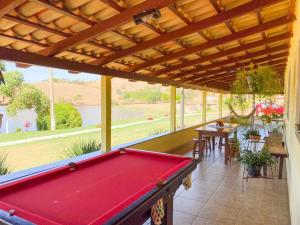 a pool table on a patio with a view of a river at Suite independente em casa de fazenda in Capitólio