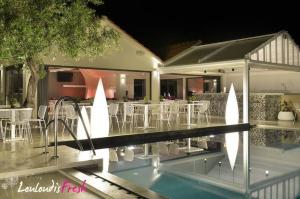 a house with a swimming pool in front of a house at Louloudis Fresh-Adults Only in Skala Rachoniou
