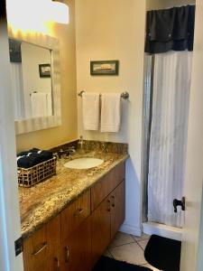 a bathroom with a sink and a mirror at See By The Sea in San Diego