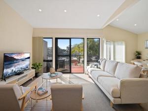 sala de estar con sofá y TV en Portside at The Arc by Experience Jervis Bay, en Vincentia