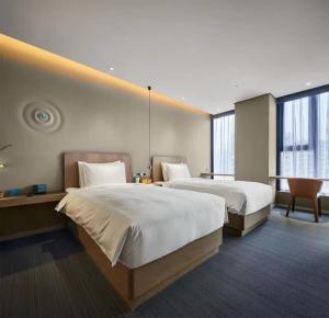 a hotel room with two beds and a desk at Ebo Hotel in Hangzhou