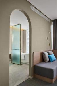 a room with a bed and a bathroom with a mirror at Ebo Hotel in Hangzhou