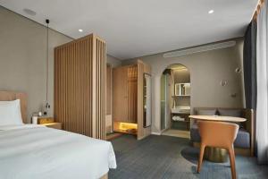 a bedroom with a bed and a desk and a table at Ebo Hotel in Hangzhou