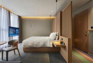 a bedroom with a bed and a table and a chair at Ebo Hotel in Hangzhou