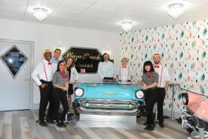 un grupo de personas de pie junto a un coche azul en Plaza Beach Hotel - Beachfront Resort, en St Pete Beach