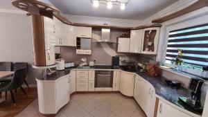 uma cozinha com armários brancos e uma bancada em Apartament DeLuxe 2 em Oświecim
