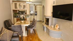 uma cozinha e sala de jantar com uma mesa e uma televisão em Apartament DeLuxe 2 em Oświecim