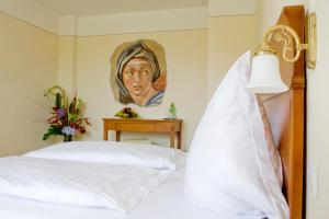 a bedroom with a bed with a painting on the wall at XII Apostel Albergo in Cologne