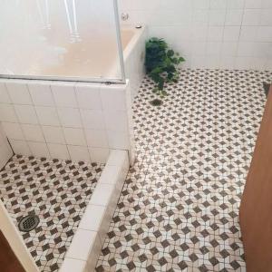 a bathroom with a shower and a tiled floor at CAMPBELLTOWN HOLIDAY HOME 3 BED + FREE PARKING NCA039 in Campbelltown