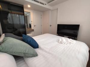 um quarto com uma cama branca com duas toalhas em Bangkok Asok Circle REIN Sukhumvit 12#2BR&3BR#Pool&Gym#Near Terminal 21 em Bangkok