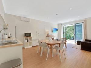 a kitchen and dining room with a table and chairs at Banksia on Blenheim by Experience Jervis Bay in Vincentia
