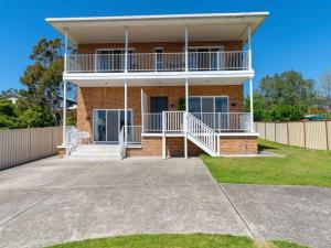 a brick house with a balcony and a driveway at Vincentia Retreat by Experience Jervis Bay in Vincentia