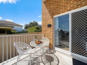 a patio with a table and chairs on a balcony at Vincentia Retreat by Experience Jervis Bay in Vincentia