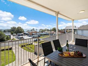 un tavolo con un piatto di cibo su un balcone di Vincentia Breeze by Experience Jervis Bay a Vincentia Altre 4 foto