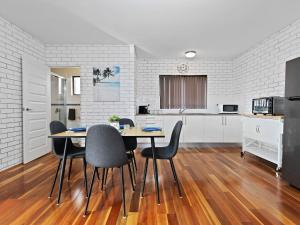 a kitchen and dining room with a table and chairs at Ammos by Experience Jervis Bay in Vincentia