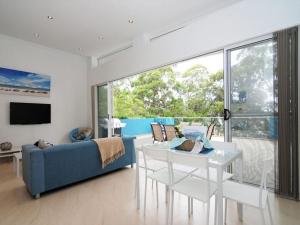 a living room with a blue couch and a table at Bombara by Experience Jervis Bay in Huskisson