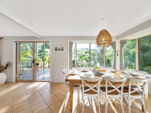 a dining room with a table and chairs at The Sanctuary at Greenfield Beach by Experience Jervis Bay in Vincentia