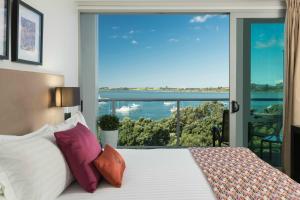 a bedroom with a bed with a view of the ocean at Hotel on Devonport in Tauranga