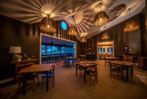 a dining room with tables and chairs and chandeliers at Woodhouse Mountain Lodge in Warkworth