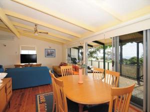 a living room with a table and a couch at Seaview by Experience Jervis Bay in Vincentia