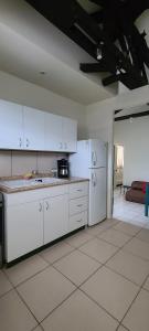 a kitchen with white cabinets and a white refrigerator at Casa Elizabeth Apartamentos in Quetzaltenango +33 photos