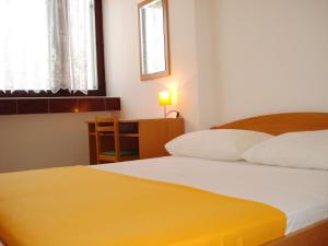 1 dormitorio con 2 camas, mesa y ventana en Apartments Nikolas, en Vodice