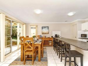 a kitchen with a table and chairs and a counter at The Porthole of Huskisson by Experience Jervis Bay in Huskisson