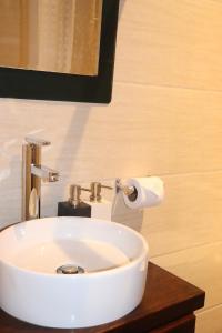 a bathroom with a white sink and a roll of toilet paper at Casa Rafaela in Cusco