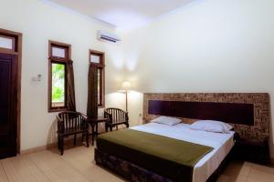Hotel Mahkota Plengkung by ecommerceloka tesisinde bir odada yatak veya yataklar