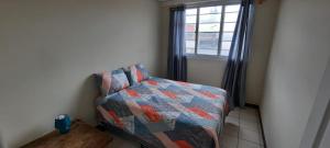 a bedroom with a bed and a window at Casa Elizabeth Apartamentos in Quetzaltenango