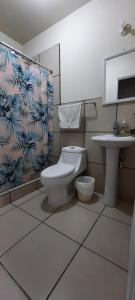 a bathroom with a toilet and a sink at Casa Elizabeth Apartamentos in Quetzaltenango