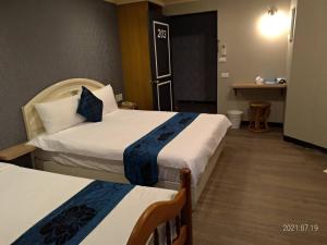 a hotel room with two beds and a table at Guan Lun Hotel in Hualien City