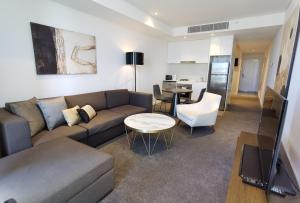 ein Wohnzimmer mit einem Sofa und einem Tisch in der Unterkunft KOZYGURU Chatswood Luxury Studio Walk to Chatswood Chase NCH088-721 in Sydney