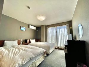 Hotel Umizola في ناها: غرفة فندقية بسريرين ونافذة