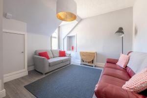 a living room with a couch and a chair at Dryburgh Apartments No2 in Inverness +5 photos