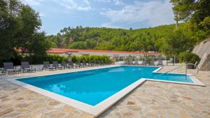 a swimming pool with chairs and a building at Scardona Park Luxury Accommodation in Skradin