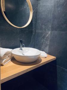 y baño con lavabo blanco y espejo. en Hôtel du Lion d'OR, en Charolles