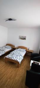 ein Zimmer mit 2 Betten und einem Sofa darin in der Unterkunft Guest House Jovanovic in Melenci