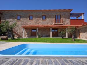 a villa with a swimming pool in front of a house at Quinta do Passadiço in Lamego