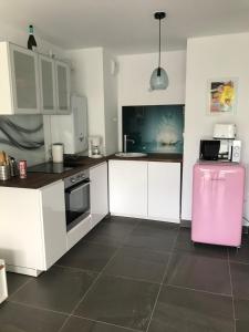 cocina con armarios blancos y nevera rosa en Appartement à Nice en Niza