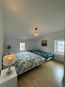 1 dormitorio con 2 camas y lámpara. en Superbe appartement avec 2 Chambres - 9 Personnes - Parking Privé, en Tournon-sur-Rhône