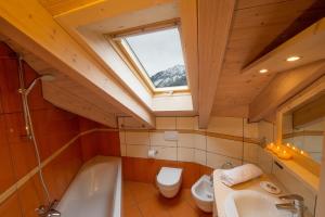 a bathroom with a sink and a toilet and a window at Chalet La Rugiada in Valdisotto