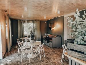 a living room with a table and chairs and a couch at VIESU MĀJA KALNARUŠĶI in Lūšakrogs