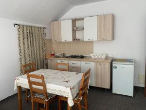 a small kitchen with a table and a table and chairs at Hygge House in Buşteni