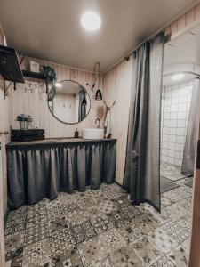 ein Bad mit einem Waschbecken und einem Spiegel in der Unterkunft VIESU MĀJA KALNARUŠĶI in Lūšakrogs
