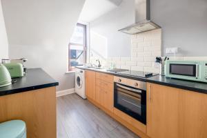 a kitchen with a microwave oven and a sink at Dryburgh Apartments No2 in Inverness