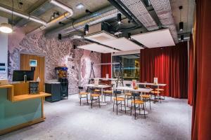 a restaurant with tables and chairs and a red curtain at ibis Styles Albertville in Albertville