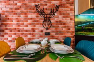 een tafel met borden en keukengerei op een bakstenen muur bij Apartament Jelonek in Jelenia Góra