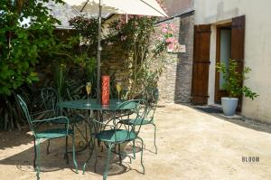 a table with chairs and an umbrella in a courtyard at Manoir de L'Aisnerie in Saint-Herblain